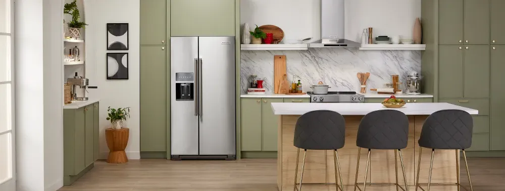 A stylish kitchen with green cabinets and a stainless steel refrigerator, combining color and modern design elements.